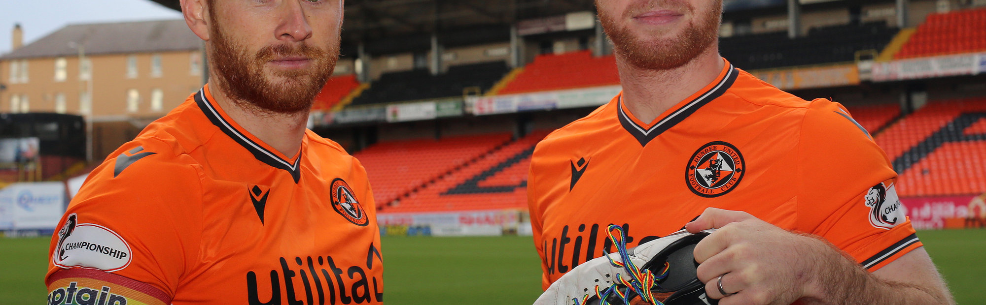 mark reynolds and mark connolly hold up the boots showing our support for rainbow laces